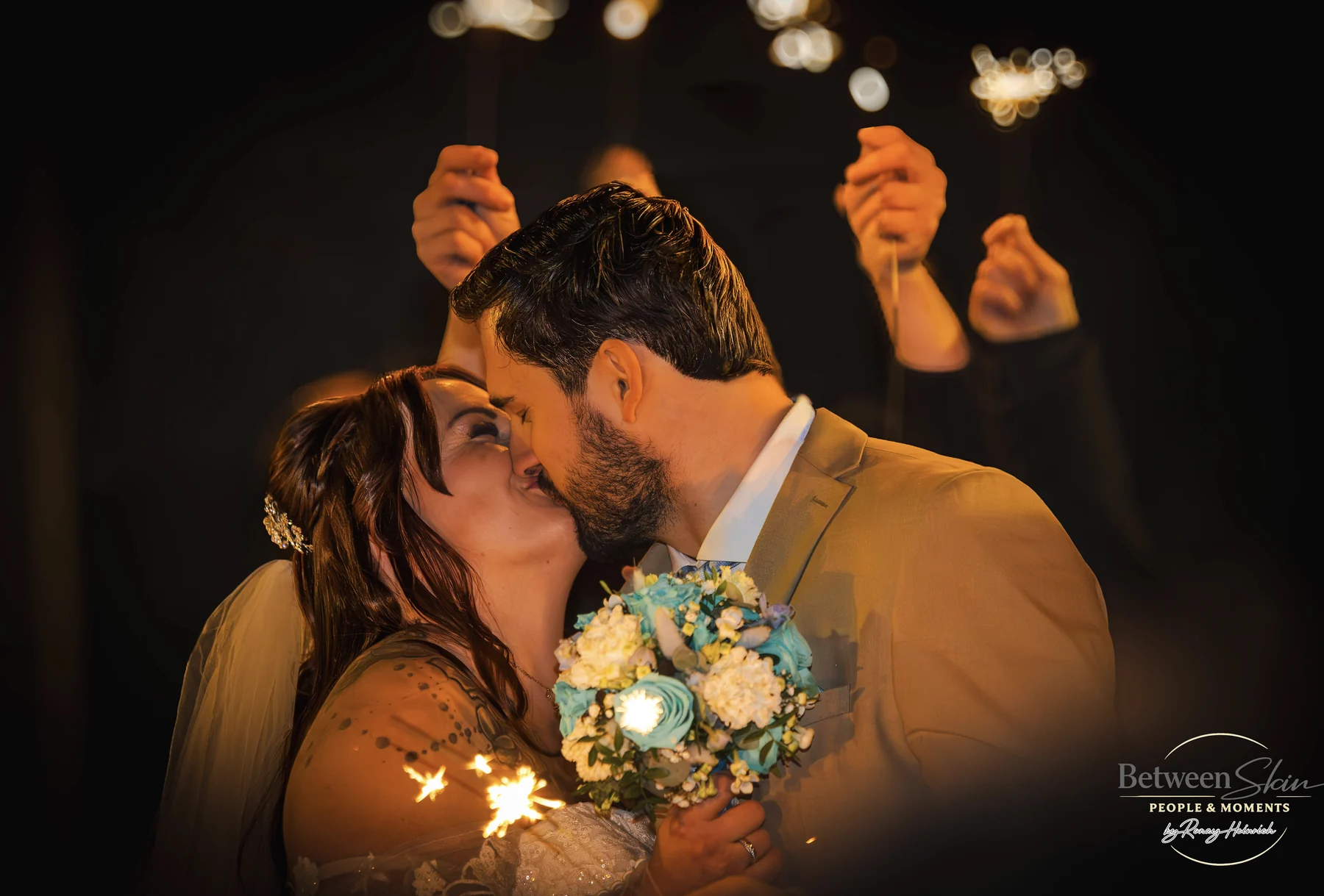 Hochzeitspaar küsst sich im Licht von Wunderkerzen
